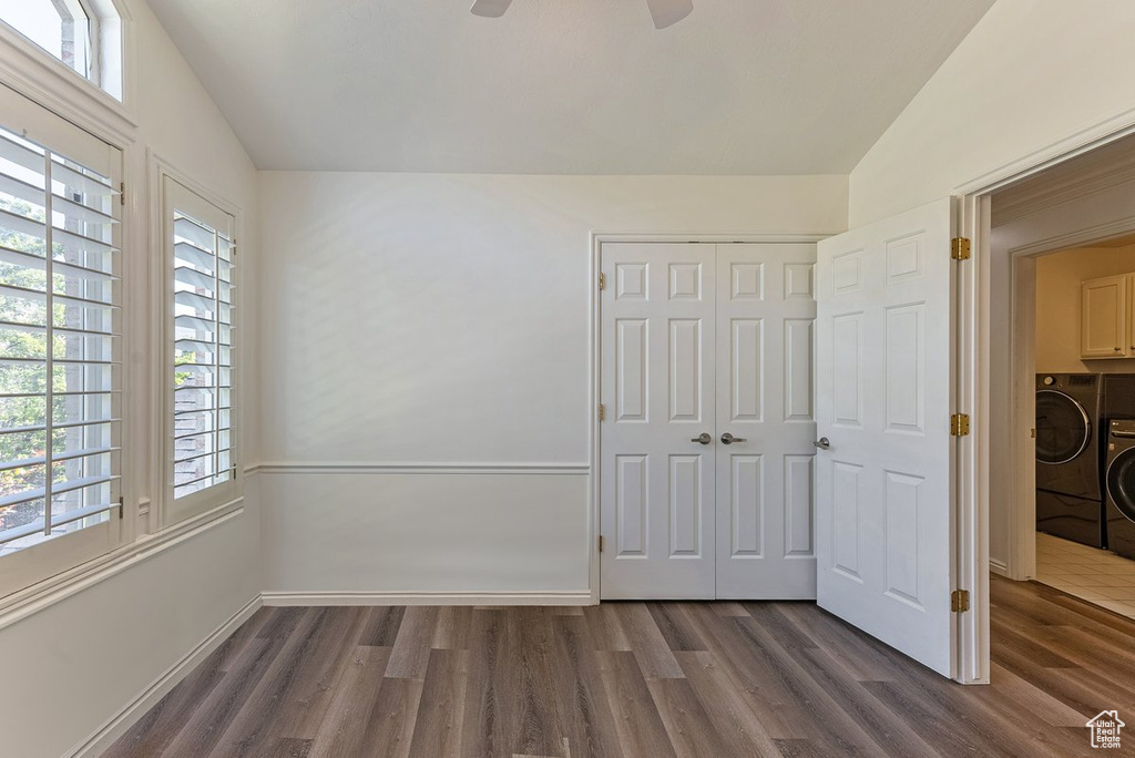Unfurnished bedroom with ceiling fan, a closet, dark hardwood / wood-style floors, and vaulted ceiling