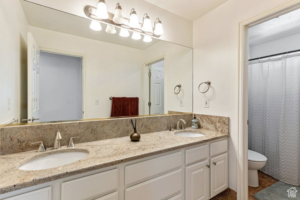 Bathroom featuring double sink vanity and toilet