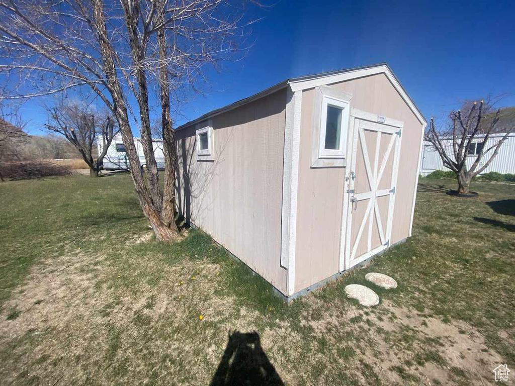 View of outdoor structure featuring a yard