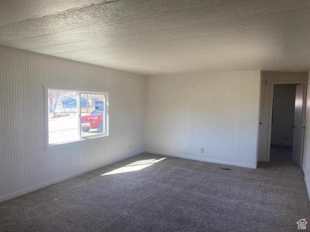 Carpeted empty room with a textured ceiling