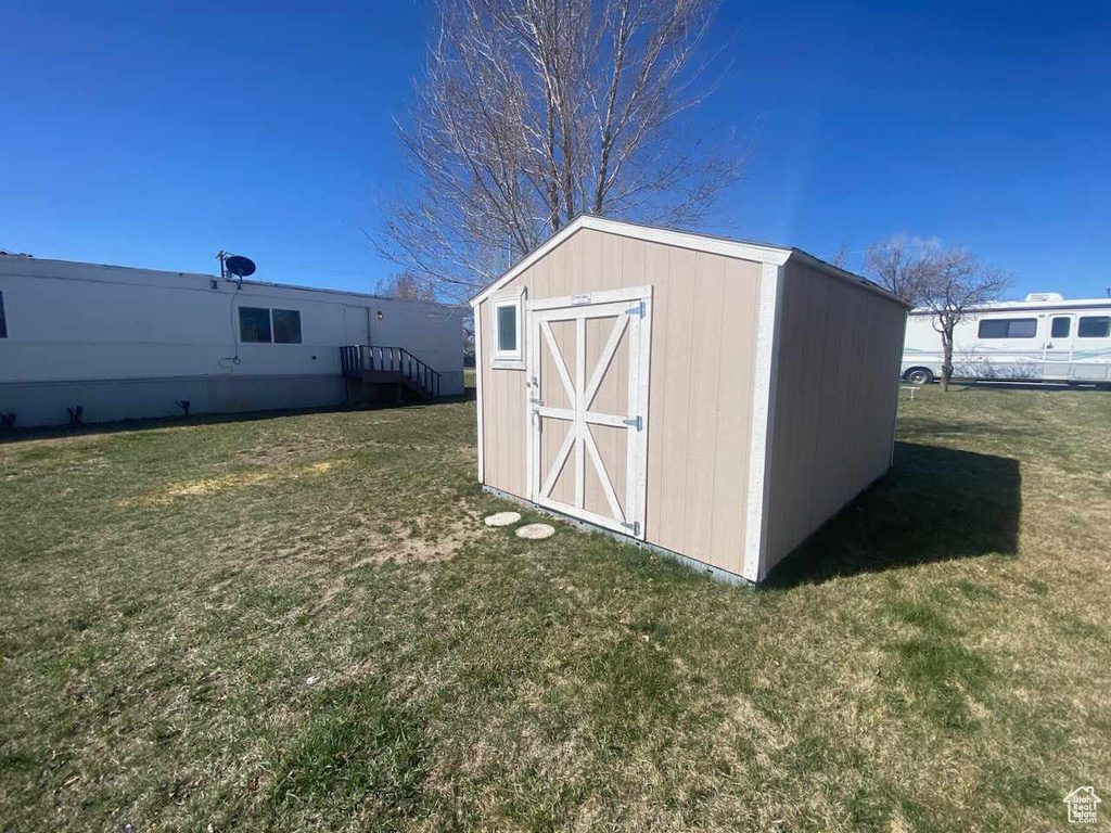 View of shed / structure featuring a lawn