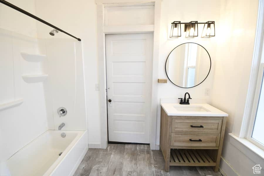Bathroom with vanity, shower / bathing tub combination, and hardwood / wood-style flooring
