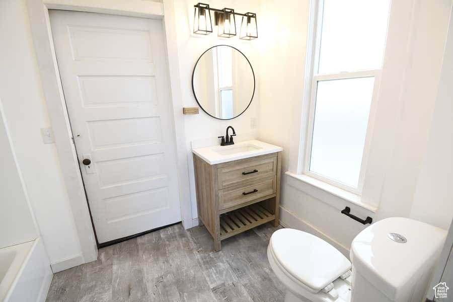 Full bathroom featuring vanity, hardwood / wood-style floors, shower / tub combination, and toilet