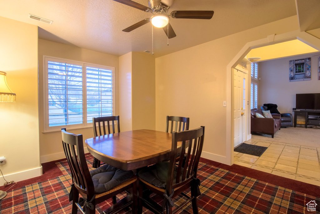 Tiled dining area featuring ceiling fan