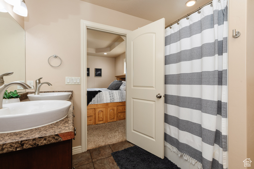 Bathroom featuring tile flooring, vanity, and a raised ceiling