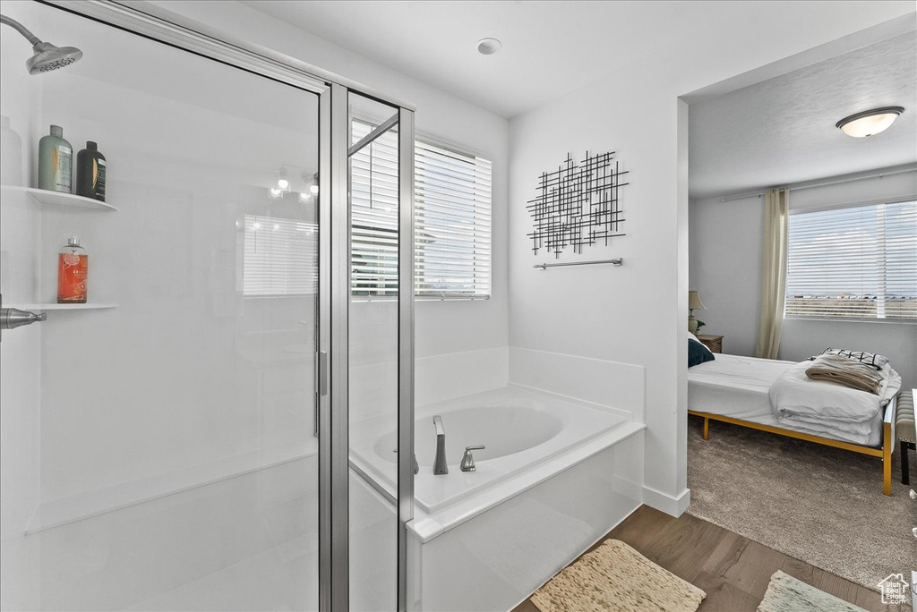 Bathroom featuring hardwood / wood-style floors and independent shower and bath