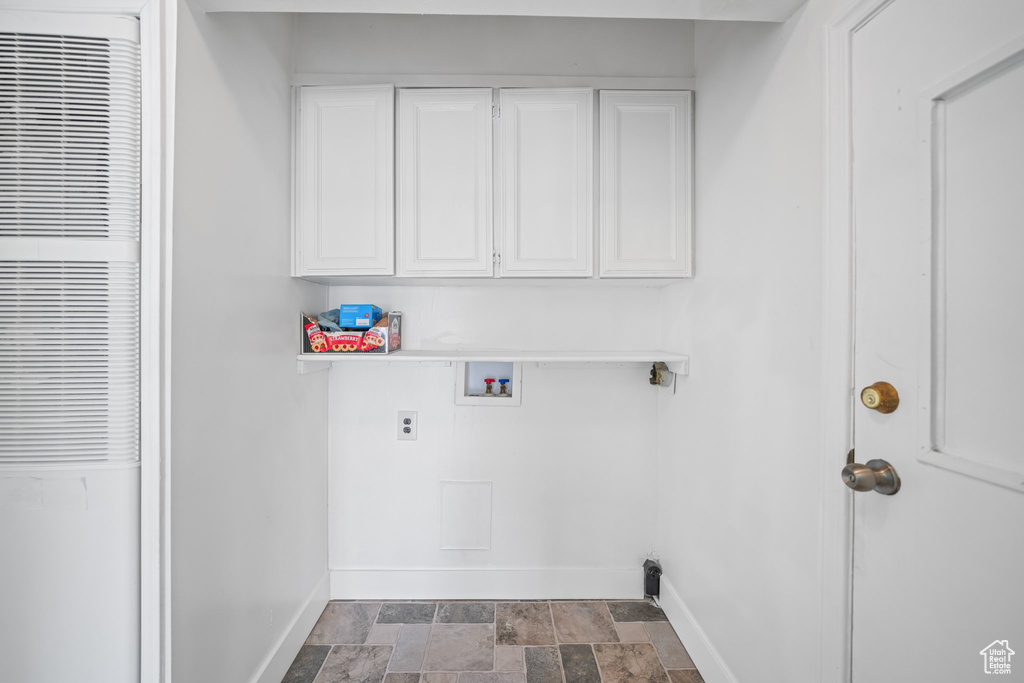 Laundry area with cabinets, dark tile floors, and hookup for a washing machine