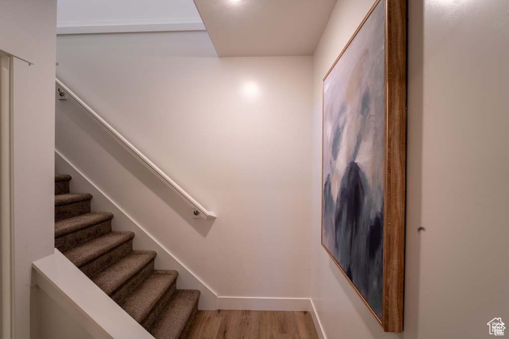 Staircase with light hardwood / wood-style floors