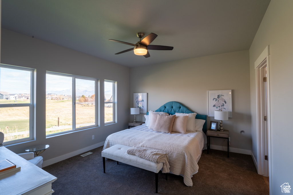 Bedroom with ceiling fan and dark colored carpet