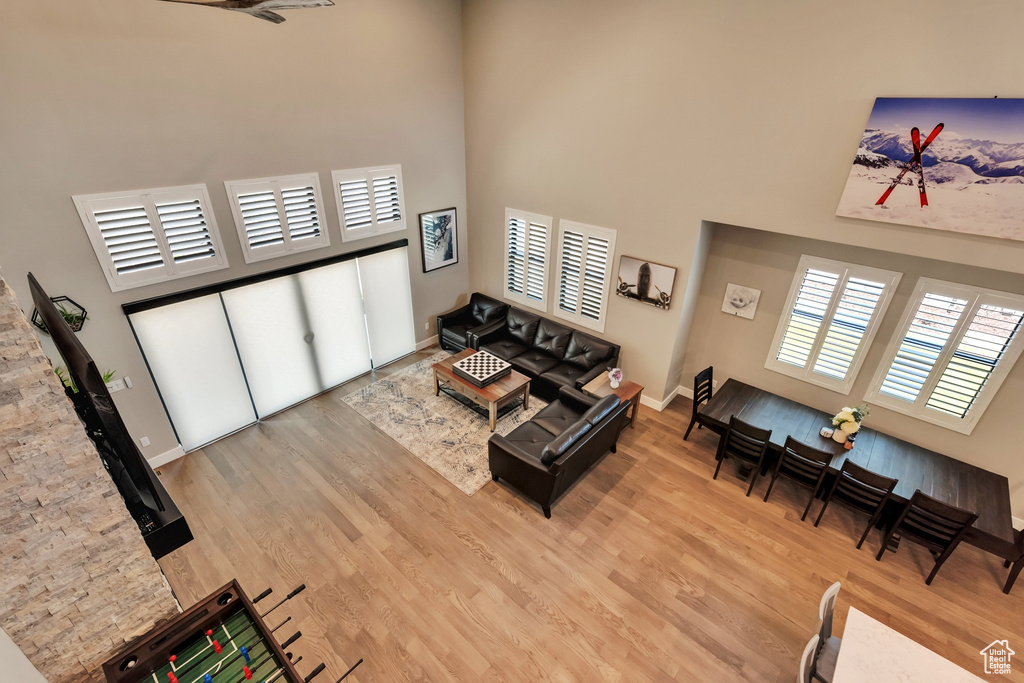 Living room with light hardwood / wood-style flooring and a high ceiling