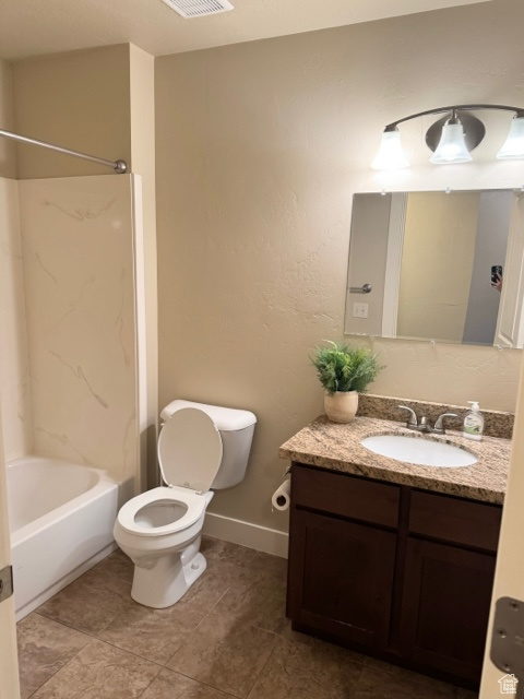 Full bathroom with toilet, tile floors, vanity, and shower / bath combination