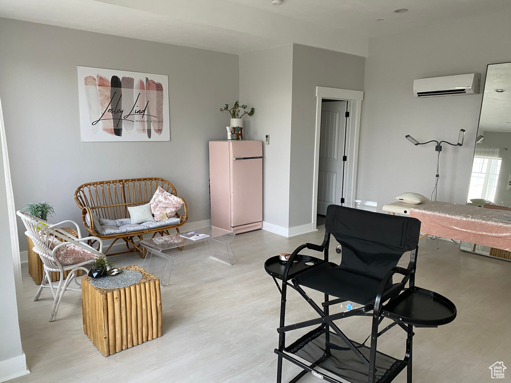 Living room featuring a wall unit AC and light hardwood / wood-style flooring