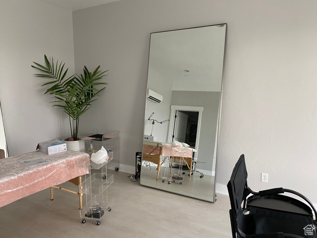 Office space featuring an AC wall unit and light wood-type flooring