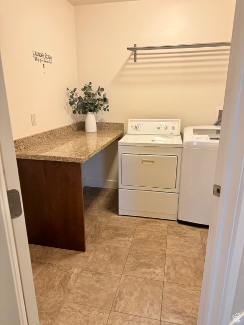 Laundry room with washing machine and clothes dryer and light tile floors