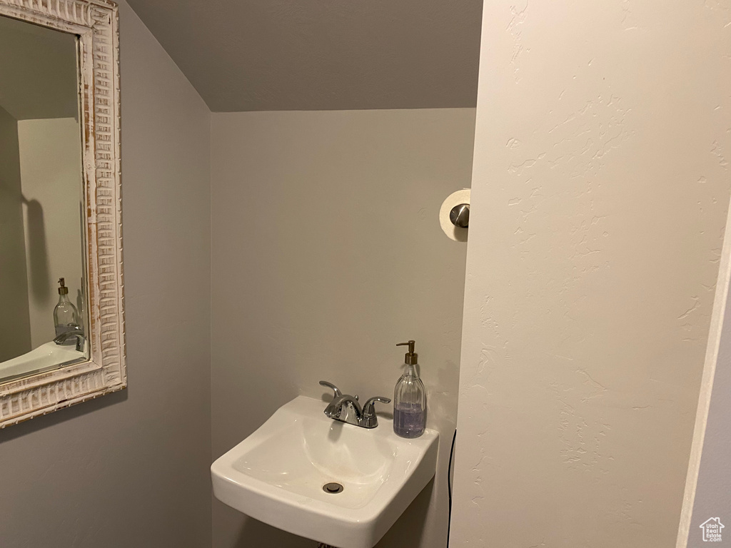 Bathroom with sink and lofted ceiling