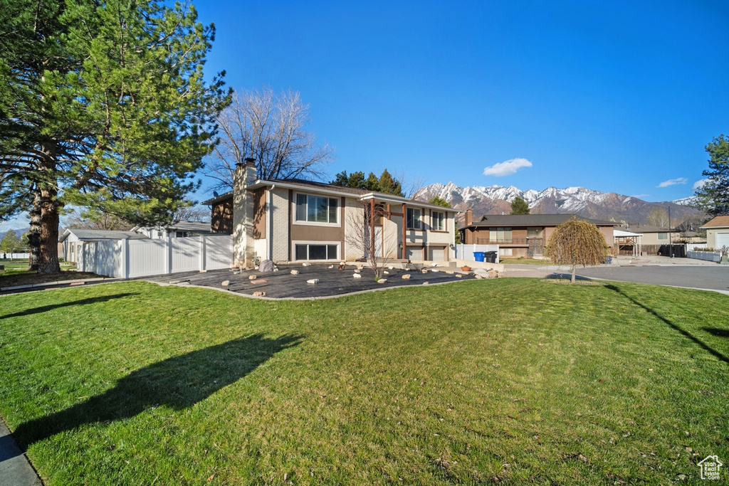 Rear view of property featuring a yard and a mountain view