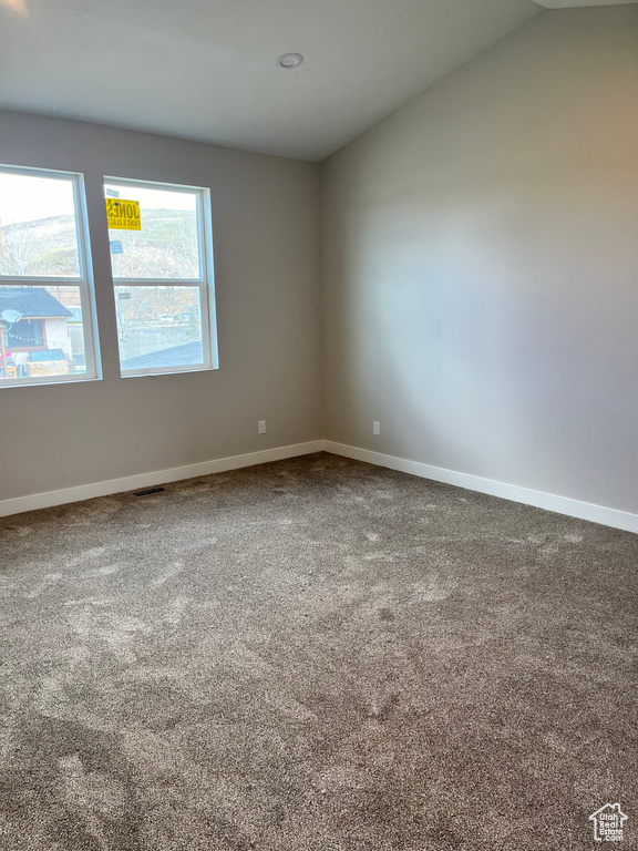 Unfurnished room with vaulted ceiling and carpet floors