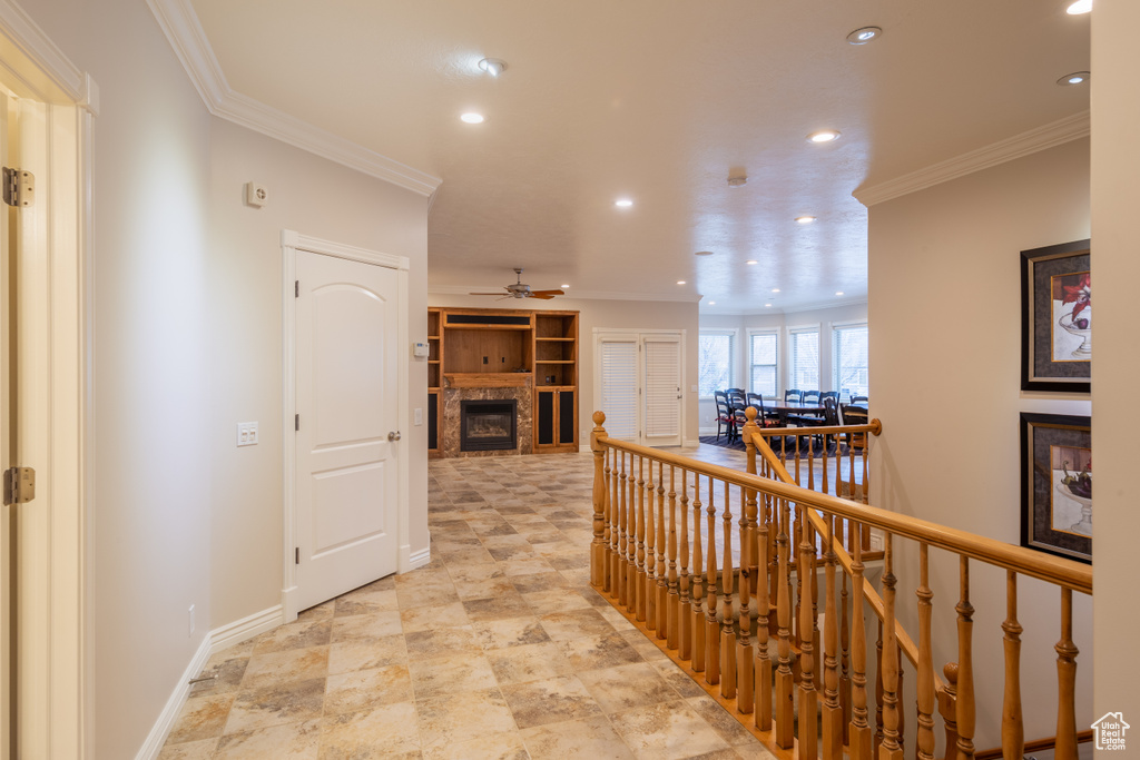 Hallway featuring ornamental molding and light tile floors