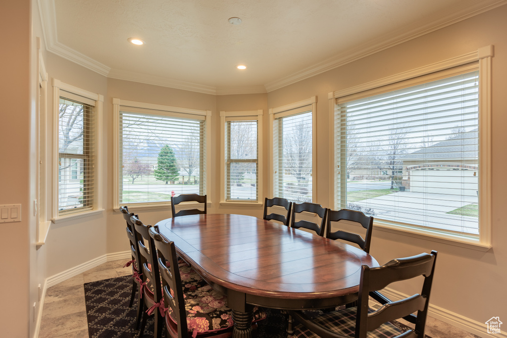 Dining room featuring tile flooring, crown molding, and a wealth of natural light