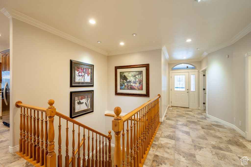 Hall with crown molding and light tile flooring