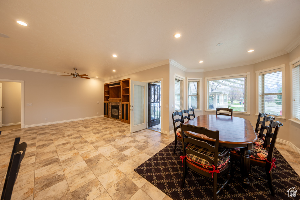 Dining space featuring light tile floors, ceiling fan, and ornamental molding