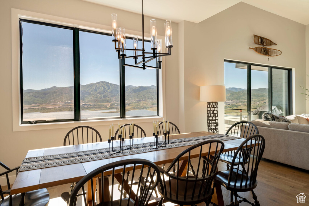 Dining area with a mountain view, dark hardwood / wood-style flooring, and an inviting chandelier
