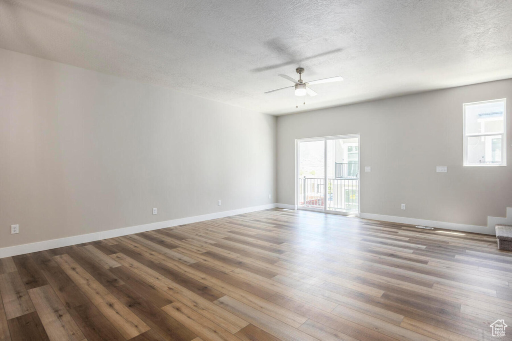 Unfurnished room with dark hardwood / wood-style floors, a textured ceiling, and ceiling fan