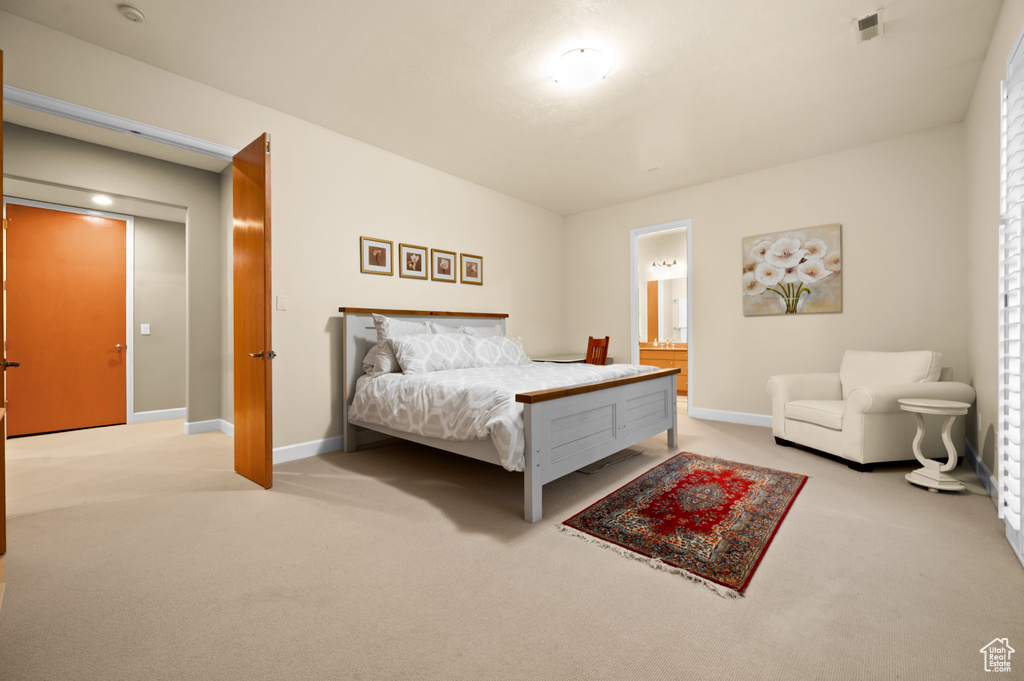 Bedroom with light colored carpet and ensuite bath