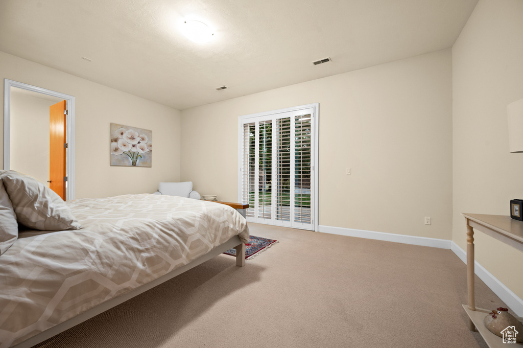 Bedroom with access to exterior and light carpet