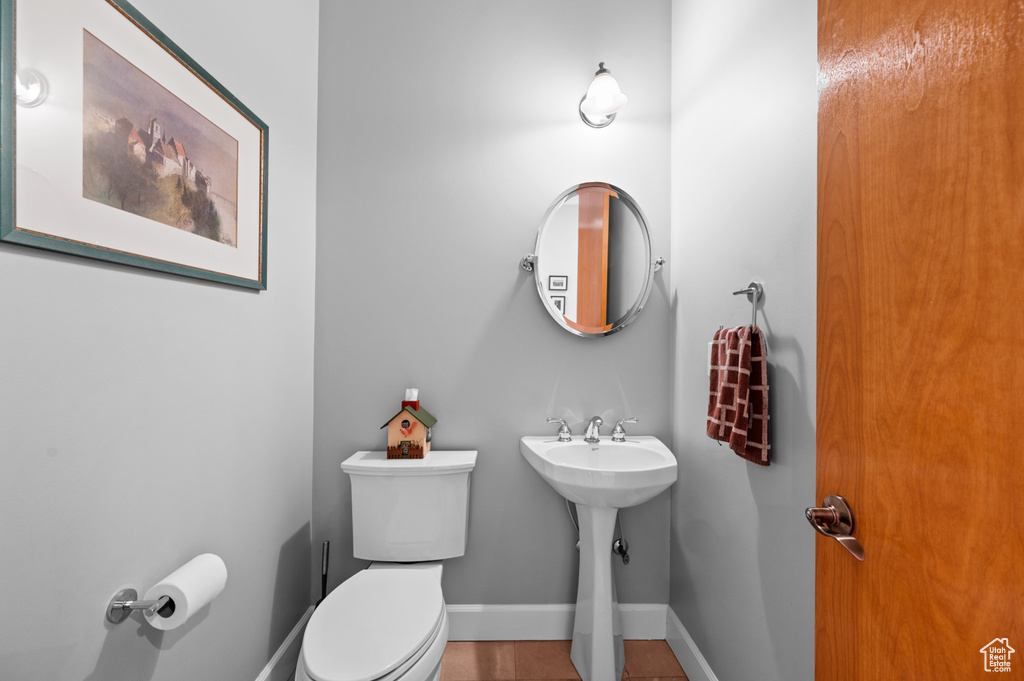 Bathroom featuring tile floors, sink, and toilet
