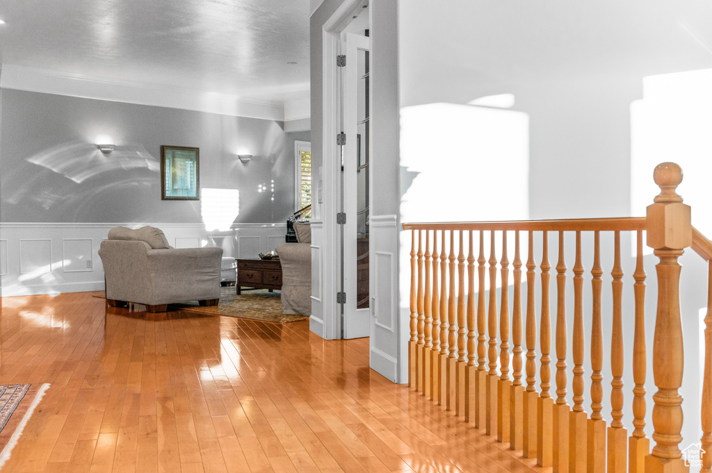 Hallway featuring light hardwood / wood-style flooring and crown molding