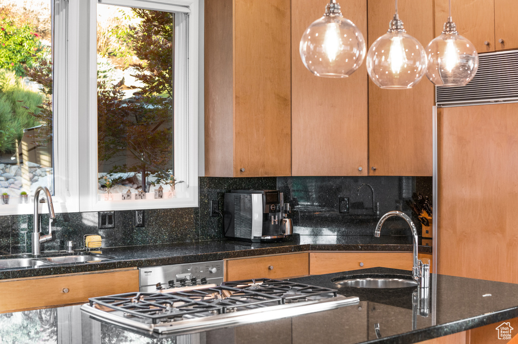 Kitchen featuring sink, pendant lighting, and backsplash