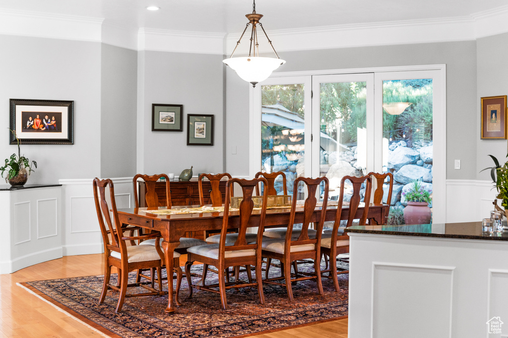 Dining space featuring ornamental molding and light hardwood / wood-style floors