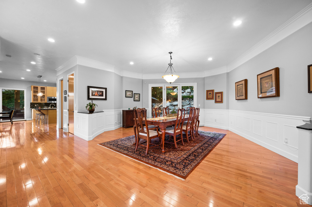 Dining space featuring crown molding and light hardwood / wood-style floors