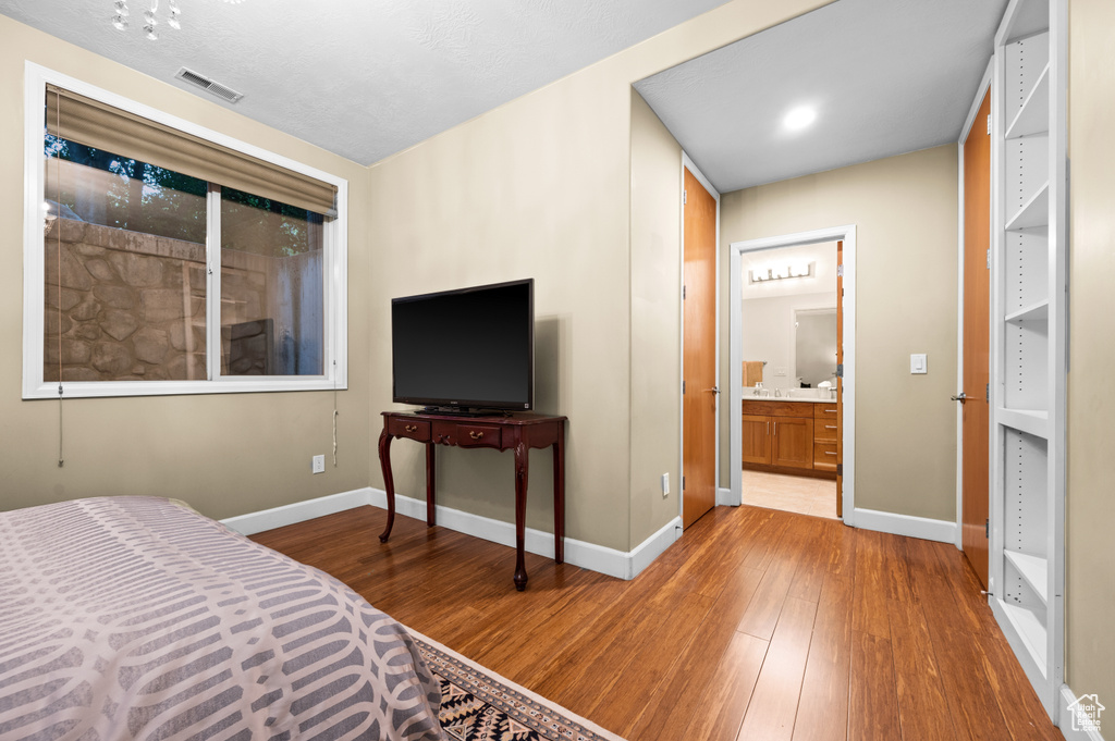 Bedroom featuring dark hardwood / wood-style flooring and ensuite bathroom