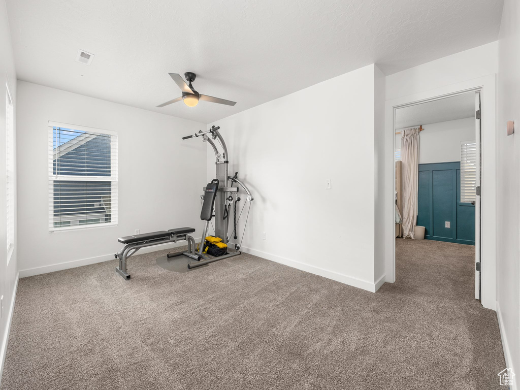 Exercise room with carpet floors and ceiling fan