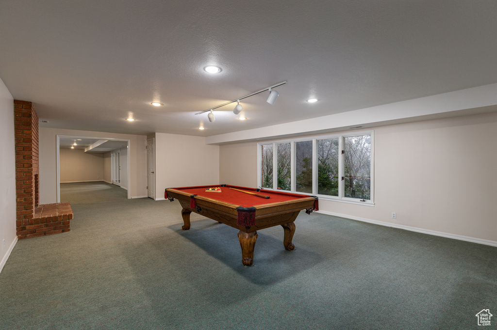 Rec room featuring brick wall, billiards, dark carpet, and track lighting