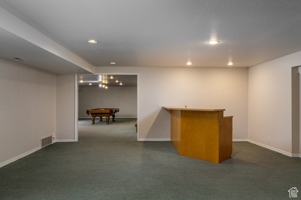 Basement with dark colored carpet and pool table