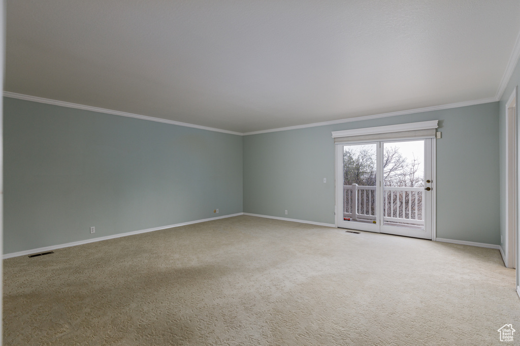 Empty room with light colored carpet and ornamental molding