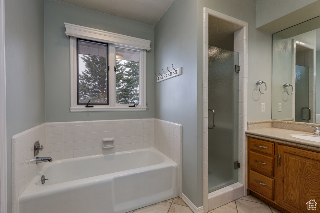 Bathroom featuring tile flooring, large vanity, and separate shower and tub