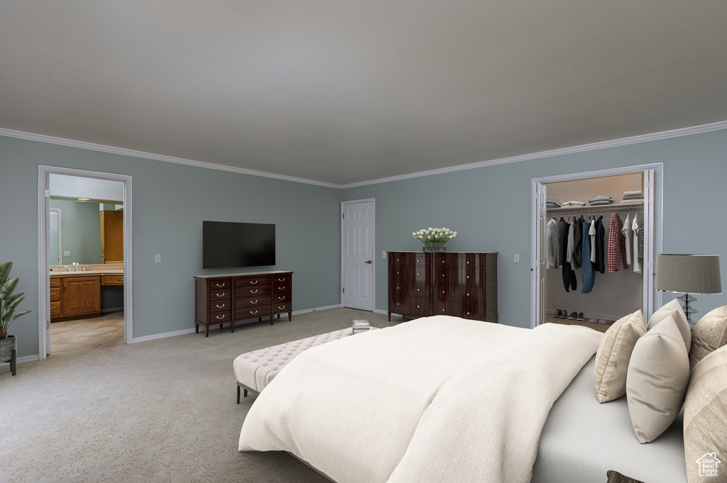 Carpeted bedroom with ensuite bath, a spacious closet, crown molding, and a closet