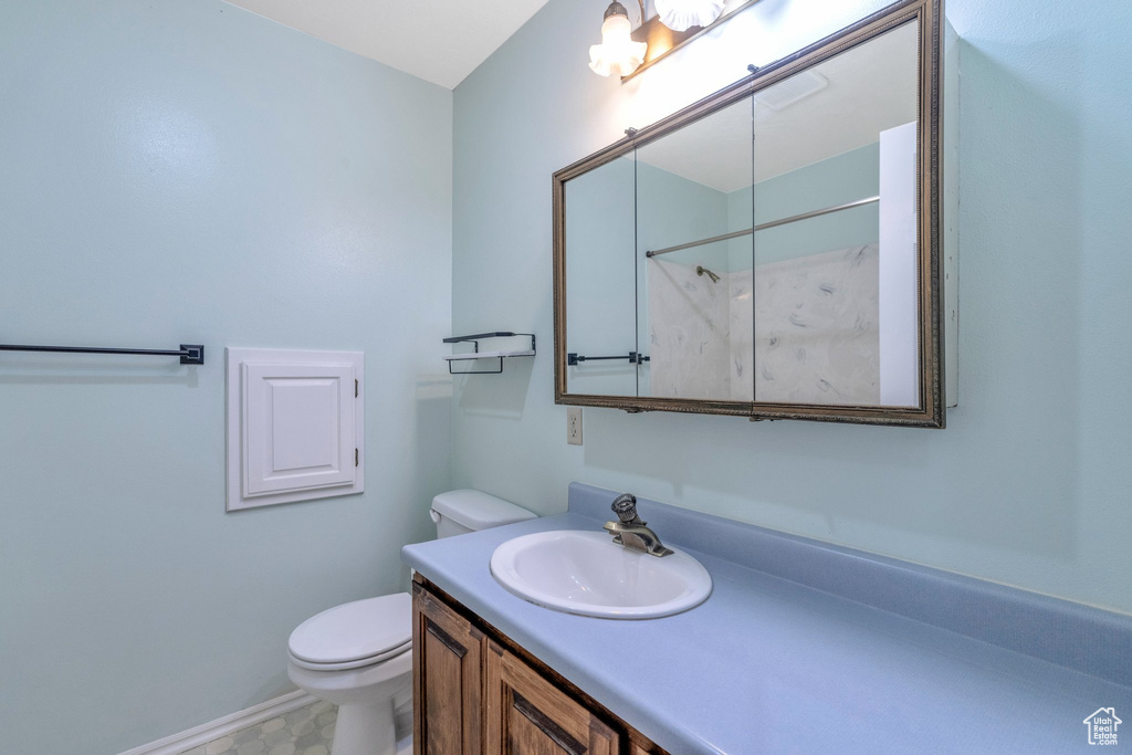 Bathroom featuring toilet, large vanity, and tile flooring