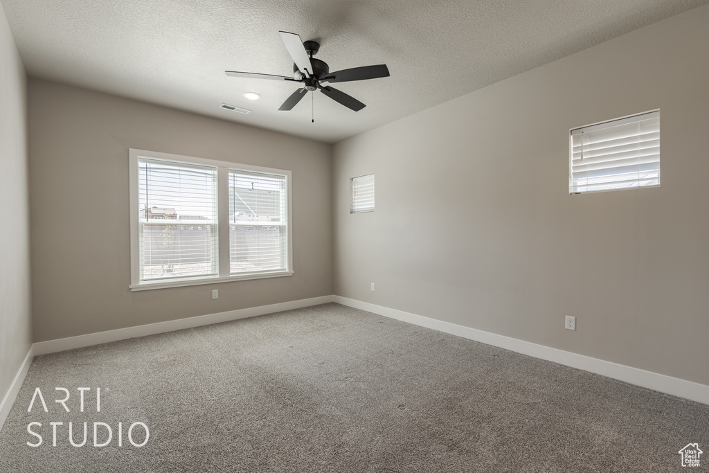 Unfurnished room with a textured ceiling, ceiling fan, and carpet flooring