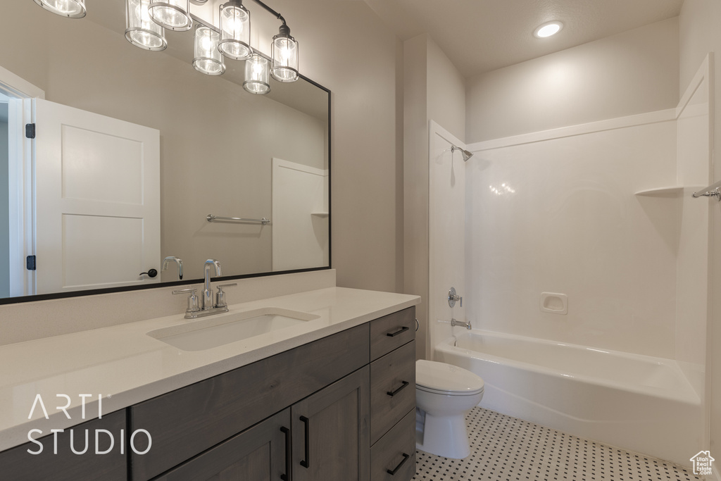 Full bathroom featuring oversized vanity, tile floors, toilet, and shower / washtub combination