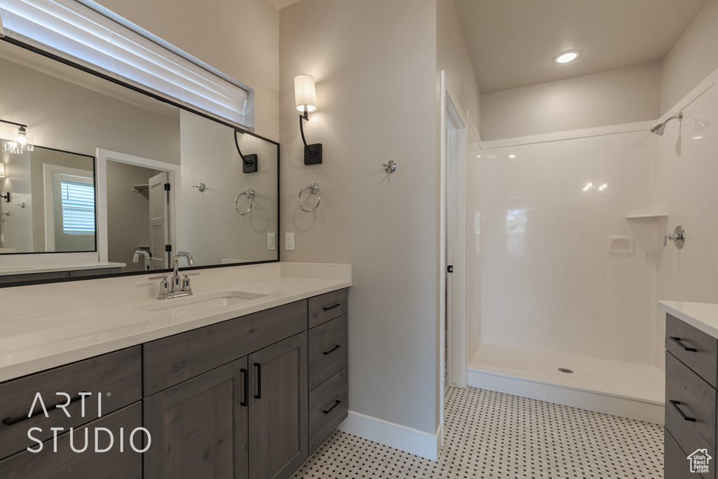 Bathroom with a shower, tile floors, and vanity