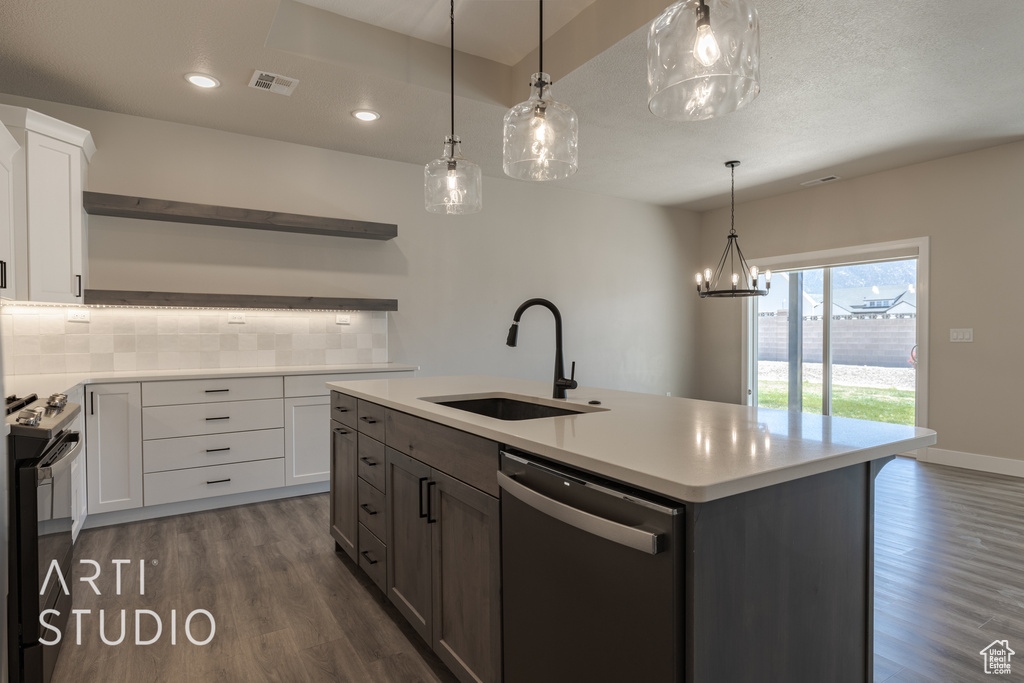 Kitchen featuring white cabinets, dishwasher, backsplash, dark hardwood / wood-style floors, and a kitchen island with sink