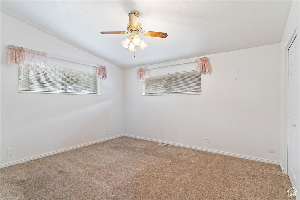 Spare room with ceiling fan, light carpet, and lofted ceiling