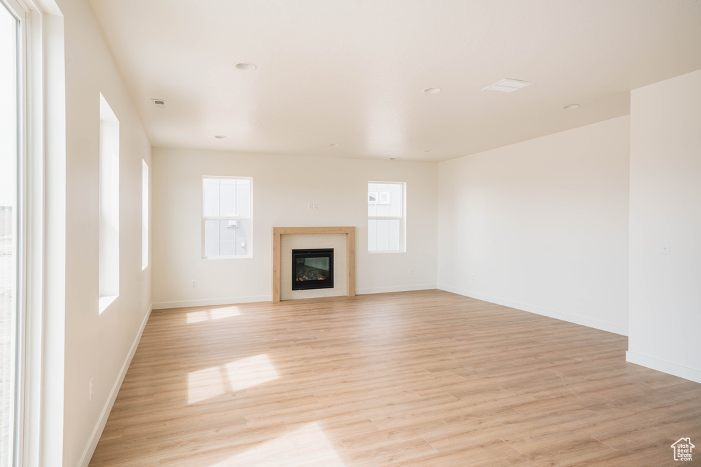 Unfurnished living room with plenty of natural light and light hardwood / wood-style flooring