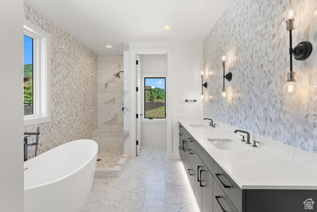 Bathroom featuring a tile shower, tile flooring, a wealth of natural light, and dual bowl vanity