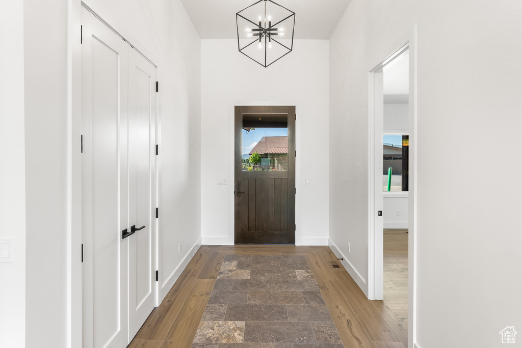 Entryway with dark wood-type flooring and a notable chandelier